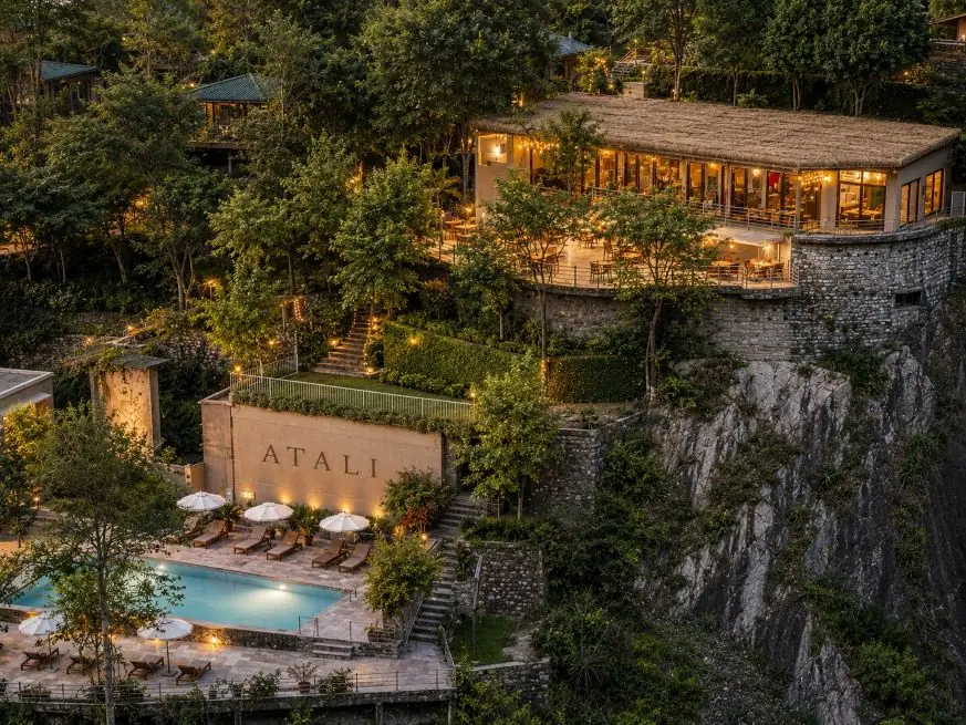 Atali Ganga property at dusk, with the pool and White Water Cafe lit up on the hillside